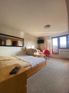 a bedroom with a large bed and a red chair at Willa Aba in Tylicz