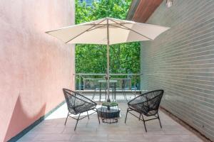 a table and chairs with an umbrella on a patio at Meneghina Suites Foresteria Lombarda in Milan