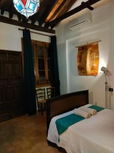 ein Schlafzimmer mit einem Bett und einem Buntglasfenster in der Unterkunft Dar Ar Nur Albaycin con patio in Granada