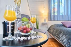 una mesa con un bol de fruta y dos vasos de zumo de naranja en Couple's Getaway in the Center of Hvar w/Sea View en Hvar