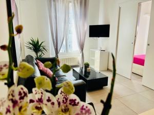 Grazioso bilocale in centro storico في فيربانيا: غرفة معيشة مع أريكة وطاولة مع زهور