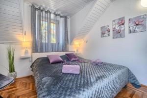 1 dormitorio con 1 cama grande con almohadas moradas en Couple's Getaway in the Center of Hvar w/Sea View, en Hvar