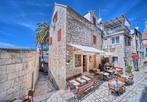 a patio with tables and chairs and a building at Couple's Getaway in the Center of Hvar w/Sea View in Hvar
