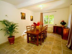 a dining room with a table and chairs and a plant at Modern Holiday Home in Le Thor with a Pool in Le Thor