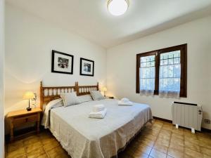 een slaapkamer met een groot bed en 2 handdoeken bij La Paliane in Calonge