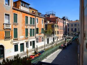 um grupo de pessoas sentadas em cadeiras em uma rua ao lado de edifícios em Hotel Corte dei Greci em Veneza