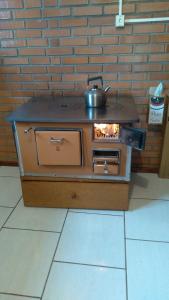 a stove with a pot sitting on top of it at Casa de campo com acesso ao Rio in Encantado