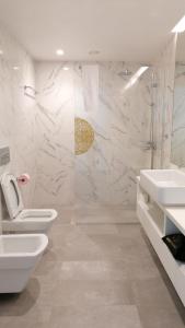 a white bathroom with two toilets and a sink at Hortas Residence 13 in Funchal
