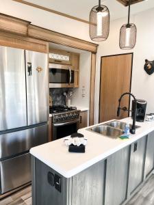 een keuken met een roestvrijstalen koelkast en een wastafel bij Pigeon Forge Landing RV Resort in Pigeon Forge