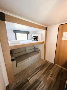 ピジョン・フォージにあるPigeon Forge Landing RV Resortのソファと窓が備わる小さな客室です。