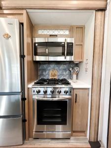 eine Küche mit einem Edelstahlherd und einer Mikrowelle in der Unterkunft Pigeon Forge Landing RV Resort in Pigeon Forge
