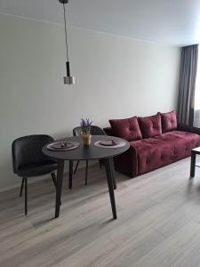 a living room with a red couch and a table at Naujai įrengtas jaukus dviejų kambarių butas in Šiauliai