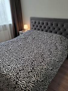 a black and white bed in a bedroom with a window at Naujai įrengtas jaukus dviejų kambarių butas in Šiauliai