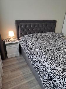 a bedroom with a black and white bed with a lamp at Naujai įrengtas jaukus dviejų kambarių butas in Šiauliai