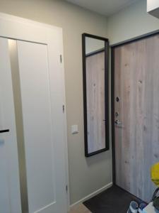 a room with a door and a mirror on the wall at Naujai įrengtas jaukus dviejų kambarių butas in Šiauliai