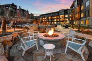 a patio with a fire pit with chairs and a table at Lift Park City in Park City