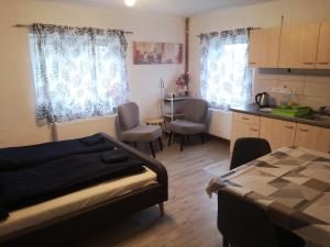 Cet appartement comprend une chambre avec un lit et une cuisine avec une table. dans l'établissement Zahrady Podluží, à Dolní Podluží