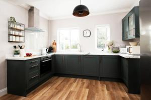a kitchen with green cabinets and a wooden floor at Beautiful 5 Bedroom House - Alnwick in Alnwick