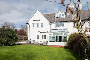 a white house with a lawn in front of it at Beautiful 5 Bedroom House - Alnwick in Alnwick