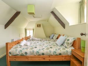 a bedroom with a wooden bed in a room at Thatch Cottage in Dorchester