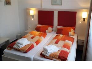 two beds sitting next to each other in a bedroom at Hotel & Restaurant Möwchen in Norden