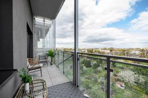 uma varanda com cadeiras e vista para a cidade em SKY Home- Penthouse Sky -Manufaktura, Bezpłatny, Parking, Klimatyzacja, Dostęp na Kod em Lódź