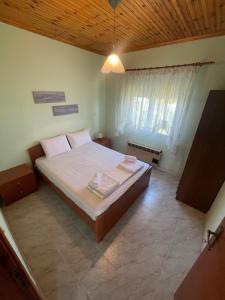 sypialnia z dużym łóżkiem i drewnianym sufitem w obiekcie Hοme4U w miejscowości Nea Kallikratia