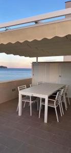 uma mesa branca e cadeiras debaixo de um guarda-sol em Duplex Penthouse em Calpe