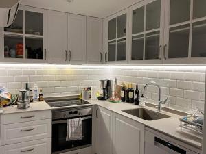 uma cozinha com armários brancos e um lavatório em Duplex Penthouse em Calpe