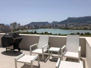 um grupo de cadeiras e um carrinho de bebé num telhado em Duplex Penthouse em Calpe