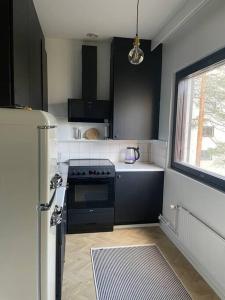 a kitchen with black and white appliances and a refrigerator at Cozy apartment in Parainen 