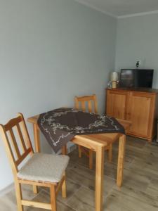 een tafel en stoelen met een tafelkleed erop bij APARTAMENT z aneksem kuchennym BARBARKI in Solina