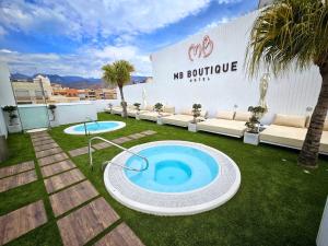 a backyard with a large pool in the grass at MB Boutique Hotel - Adults Recommended in Nerja