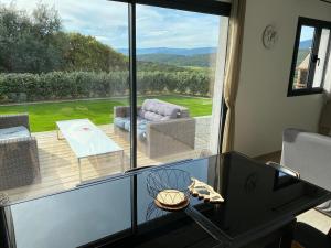 een woonkamer met een glazen tafel en een groot raam bij Brindingaccia in Propriano