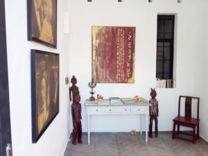 a room with a white desk and paintings on the wall at Cytyz Appart Hôtel in Mahajanga