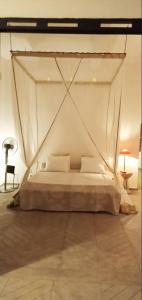 a bedroom with a bed with a mosquito net at Cytyz Appart Hôtel in Mahajanga