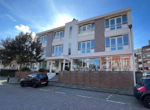 a building with a car parked in front of it at Hotel Golfzicht in Noordwijk aan Zee