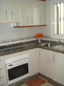 een witte keuken met een wastafel en een fornuis bij Apartamento Andalucía in Córdoba