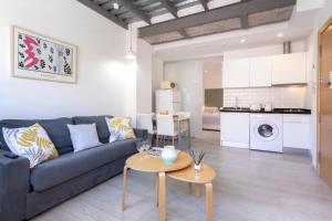 ein Wohnzimmer mit einem Sofa und einem Tisch in der Unterkunft Livemalaga Pedregalejo in Málaga