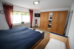 Un dormitorio con una cama azul y una ventana en Komfort Ferienwohnung FEWO 74-3 en Bremm