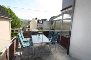patio con mesa y sillas en el balcón en Komfort Ferienwohnung FEWO 74-3 en Bremm