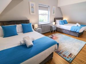 two beds in a room with blue and white at The Hideaway in Magherafelt