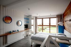 a bedroom with a bed and a large window at Apartament dwupoziomowy Yakima in Puck