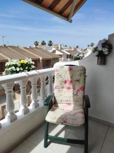 Torre de la Horadada的住宿－Sun And Beach Torre Horadada，一张椅子位于享有城市美景的阳台上