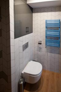 a white bathroom with a toilet and a mirror at Apartament dwupoziomowy Yakima in Puck +20 photos