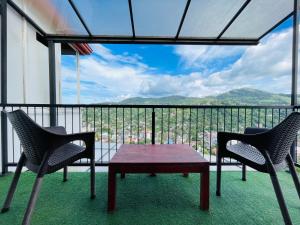 two chairs and a table on a balcony with a view at The SkyDeck Kandy in Kandy