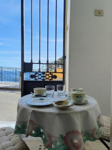 un tavolo con piatti e bicchieri di Casa La Bionda a Positano