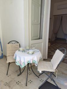 mesa con 2 sillas y mesa con mantel blanco en Casa La Bionda en Positano