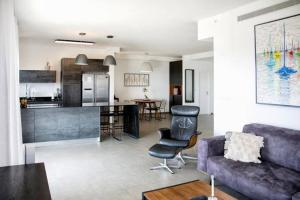 een woonkamer en een keuken met een bank en een tafel bij A large and well-designed apartment with a stunning view in Or ‘Aqīvāh