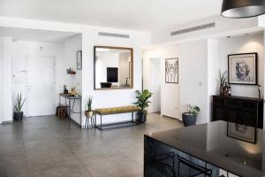 een woonkamer met een bank en een spiegel bij A large and well-designed apartment with a stunning view in Or ‘Aqīvāh